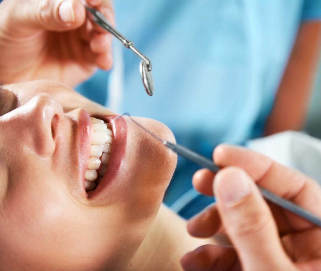 smiling woman with dental tools near her teeth