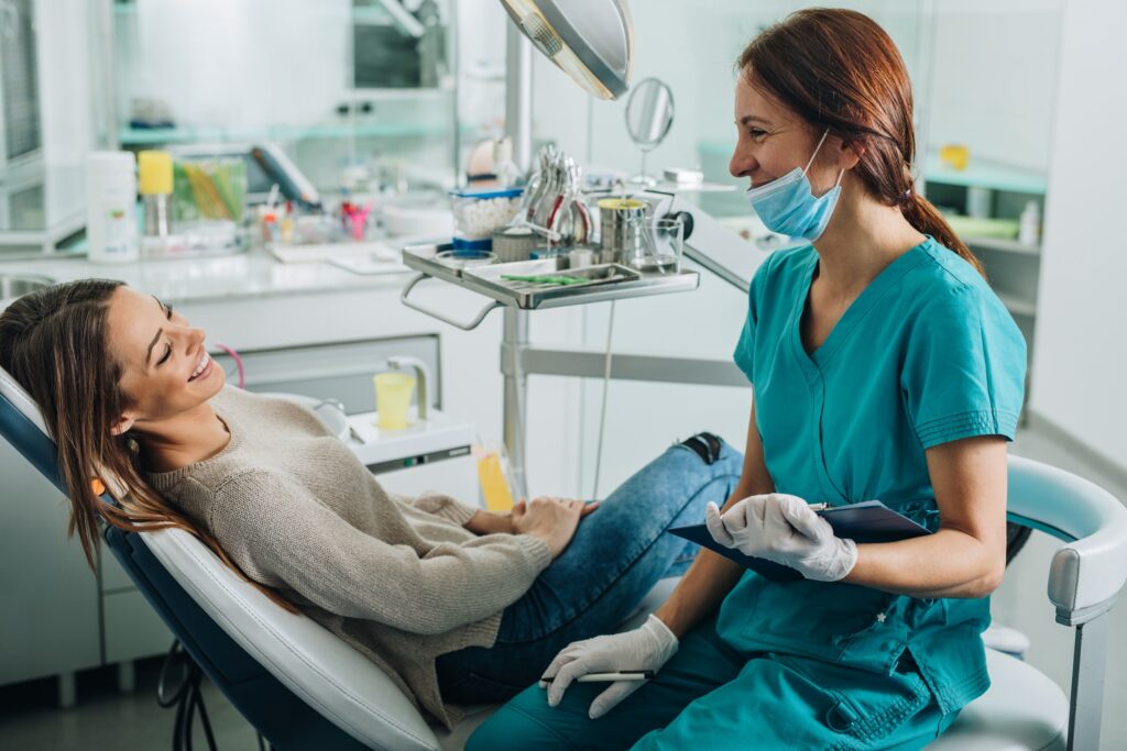 dental assistant smiling at a patient in a patient chair